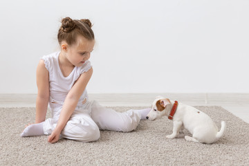 Children, pets and animal concept - Child girl play with her Jack Russell Terrier puppy indoors