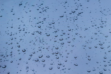 Abstract background with raindrops on the window in blue tone
