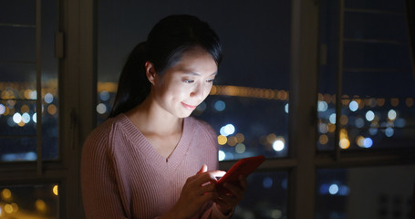 Woman check on mobile phone at night