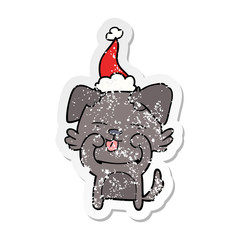 distressed sticker cartoon of a dog rubbing eyes wearing santa hat
