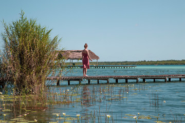 Woman on the wooden pier in the lagoon of Bacalar (lagoon of the seven colors),Quintana roo , Mexico