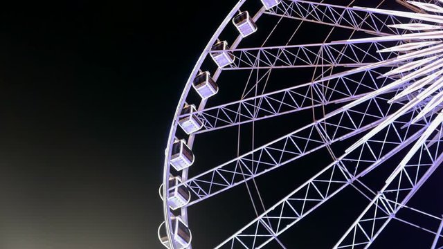 Time lapse video of a gaint Ferris wheel in the night with a beautiful lighting