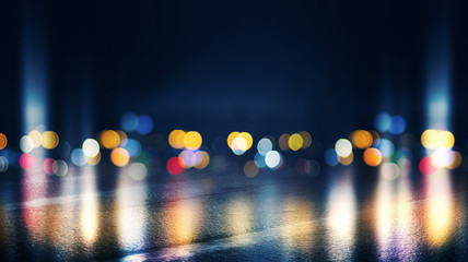 Dark empty stage, multicolored rays of neon searchlight, wet asphalt, smoke, night shooting, bokeh...