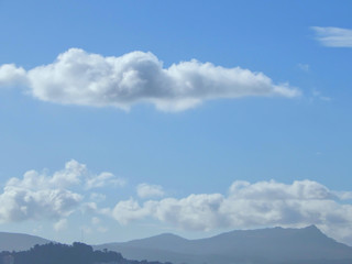 clouds in the blue sky over mountains in the north of Spain