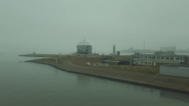 Slow pan right to left, harbour with military looking building in Den Helder, Netherlands.