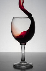 red wine splashing out of a glass, isolated on white