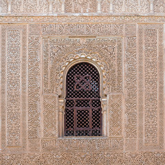 Detail of an arched window decorated with Moorish motifs in the Nasrid Palaces of the Alhambra. Granada, Spain