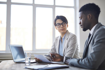 Obraz premium Young serious employee in formalwear listening to her colleague and looking at him during his explanations