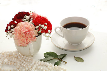 cup of coffee and a bouquet of flowers on a white background, a beautiful morning and the arrival of spring