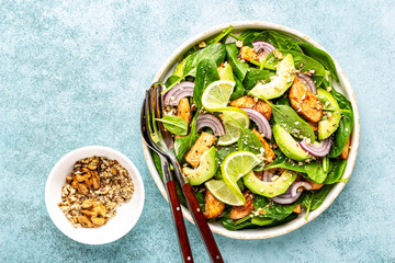 Healthy avocado salad with chicken breast and spinach, flat lay, top view