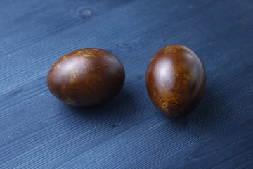 Easter eggs bronze on blue wooden background