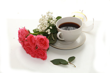 cup of coffee and a bouquet of flowers on a white background, a beautiful morning and the arrival...