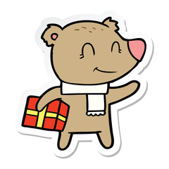 sticker of a friendly bear with xmas gift and scarf