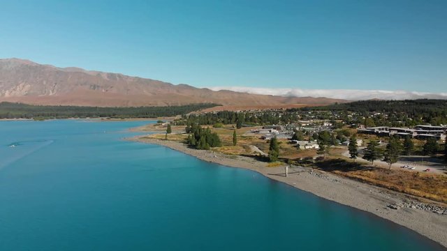 Aerial shot of Lake Tekapo, New Zealand and its Beautiful Turquoise Blue Water wiht mountains in background