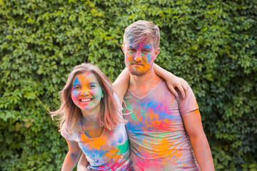 Fototapeta premium Holiday, holi and people concept - Happy couple having fun covered in paint