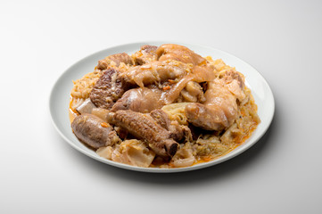 White plate with pork meat and savoy cabbage