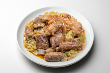 White plate with pork meat and savoy cabbage