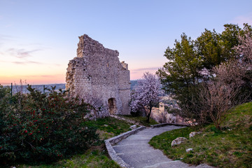 Vue sur les ruines d'ancien château de Ventabren, Provence, France. Amandiers en fleurs, coucher de soleil.  © Marina