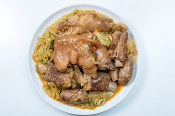 White plate with pork meat and savoy cabbage