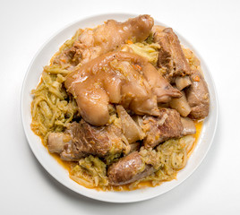 White plate with pork meat and savoy cabbage