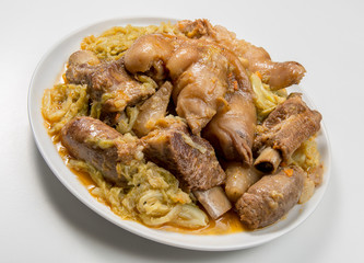 White plate with pork meat and savoy cabbage