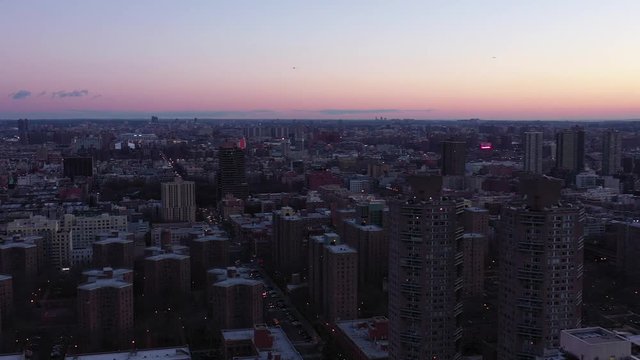 Panoramic drone pan of New York City's Harlem neighborhood at daybreak sunrise blue hour with birds flying.  Epic vista of Upper Manhattan in 4K.