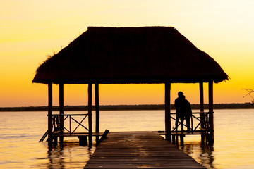 Bacalar, Mexico -January 20,2019; Friends watching the sunset at the pier of the Bacalar Lagoon(lagoon of the seven colors) Quintana Roo Mexico