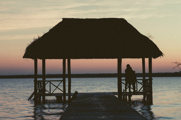 Bacalar, Mexico -January 20,2019; Friends watching the sunset at the pier of the Bacalar Lagoon(lagoon of the seven colors) Quintana Roo Mexico