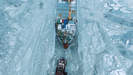 Aerial view. The big ship sails through the sea ice in the winter, close-up