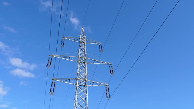 Time Lapse - 110 kilovolt Electrical Power Pylon with Clouds Passing by on a Blue Sky