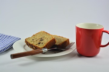 slices of homemade banana cake on a white plate on a white background