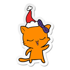 sticker cartoon of a cat with bow on head wearing santa hat