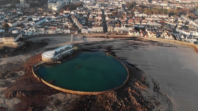 Aerial shot tilting down, Havre de Pas bathing pool at low tide, St Helier, Jersey, Channel Islands, 4k