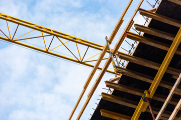Scaffolding and yellow industrial crane