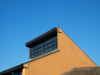 Exterior of modern roof with window against blue sky. Bracknell Forest Berkshire