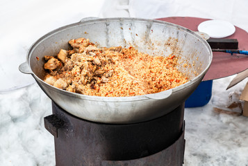 Cooking pilaf with meat in a large cauldron