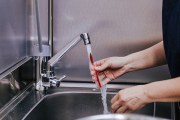 close up Of Female Baker Washing Utensil. Indoor