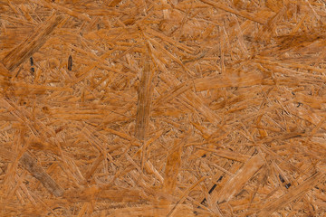 A horizontal texture of yellow chipboard for construction with knots