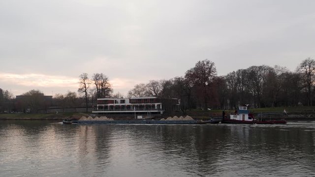 Barge carrying materials on the Meuse river in Maastricht, Netherlands, Canal Boat transporting goods, 4k footage of a long boat