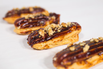 Food, bakery and desserts concept - row of eclairs on white background