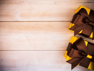 Gift boxes with brown ribbons on wooden board. Holidays concept