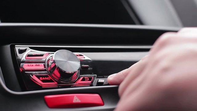 Transportation and vehicle concept - man using car audio stereo system