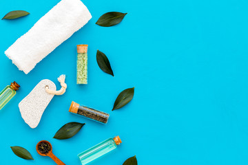 Tea tree spa composition. Fresh tea tree leaves, natural cosmetics, towel on blue background top view space for text border