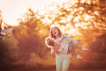 Fototapeta premium Mother and little daughter playing together outdoor