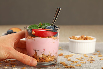 Woman eating muesli granola breakfast with yogurt