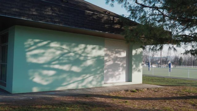 Dolly movement showing a beautiful blue wall with shadows of a tree lit by a sunrise in Malemort, brive, correze, france