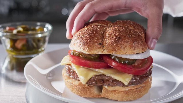 Cheff putting top whole grain bun on burger