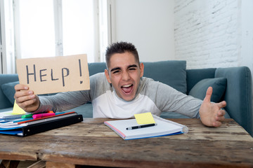 Young desperate student in stress working and studying holding a help sign.
