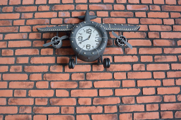 Clock plane on a brick wall