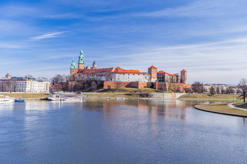 Obraz premium Wawel Royal Castle famous landmark in Krakow Poland. Picturesque landscape on coast river Vistula. Blue sky and cloud. February 23, 2019.